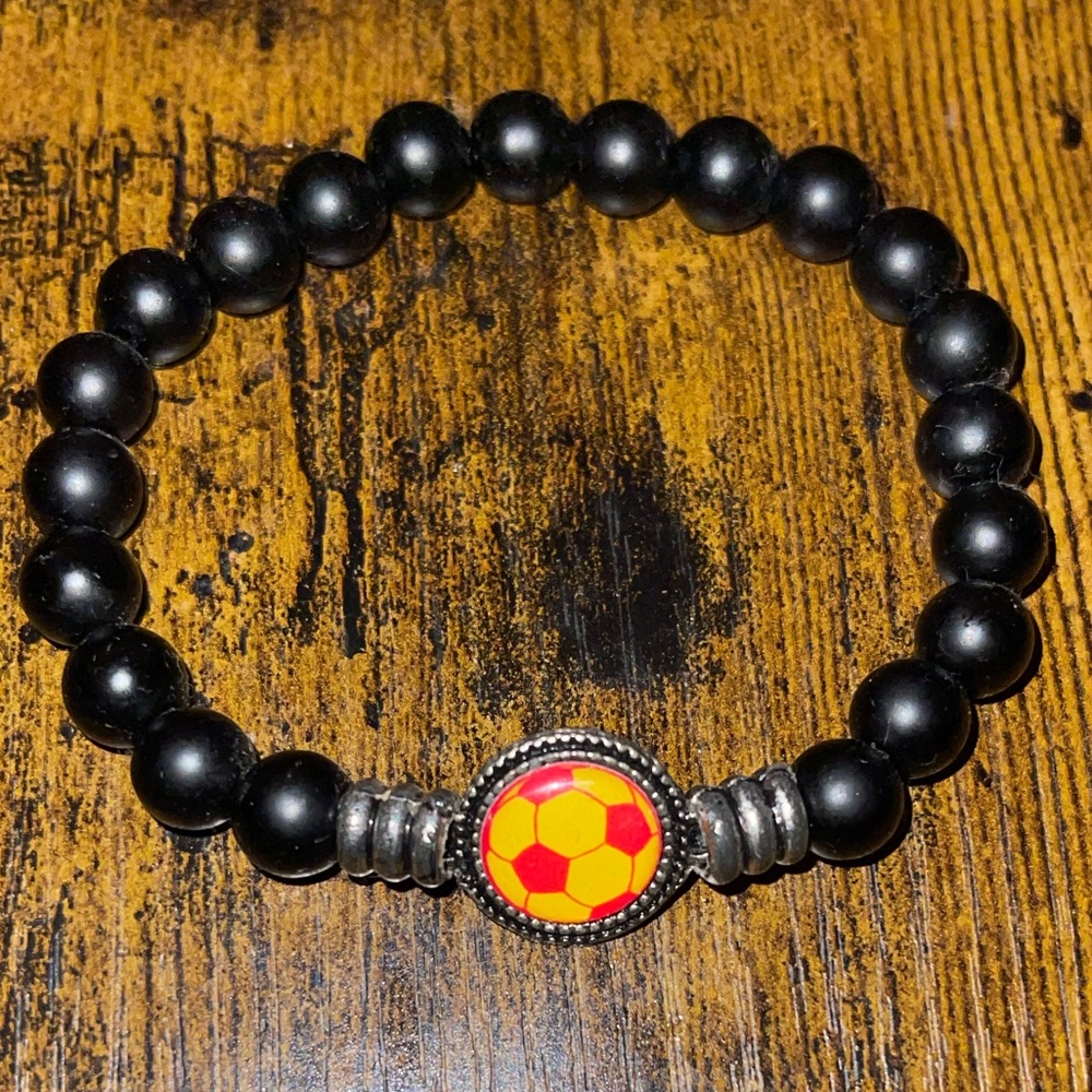 This is a matte black onyx beaded bracelet with a soccer ball charm.